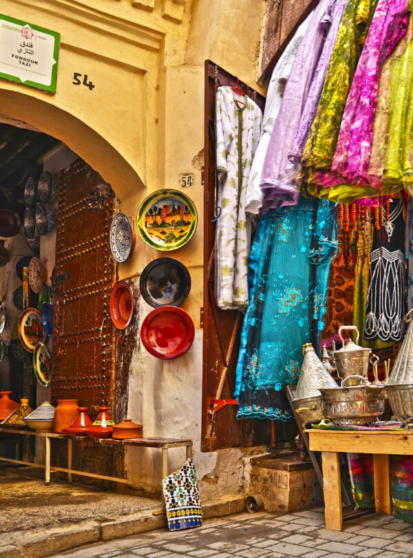 Tourists exploring narrow alleys of Marrakech medina with guide Traditional Moroccan tiles and fountain in a secret medina garden Local artisan crafting leather goods in a Marrakech souk moroccotravelbliss